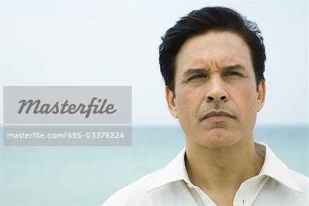 Man looking away, sea in background, portrait