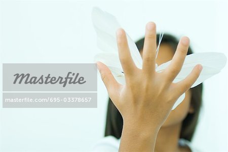 Little girl holding butterfly, hand in front of face, low angle view