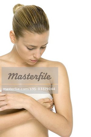 Woman covering breast with bandage, looking down