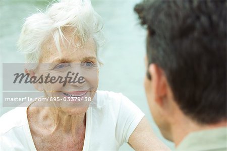 Senior woman smiling at man, over the shoulder view