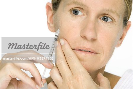 Woman giving herself botox injection, close-up