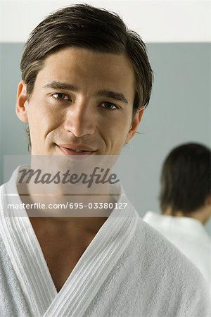 Man in bathrobe smiling at camera, portrait