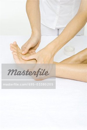 Woman receiving foot massage, cropped view