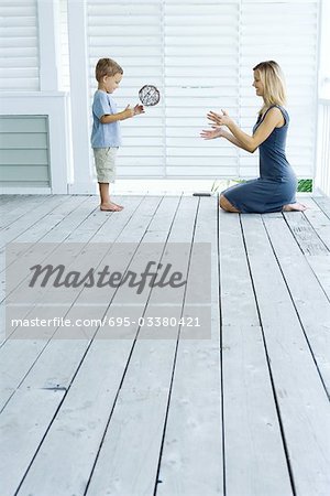 Mother and son playing catch on porch