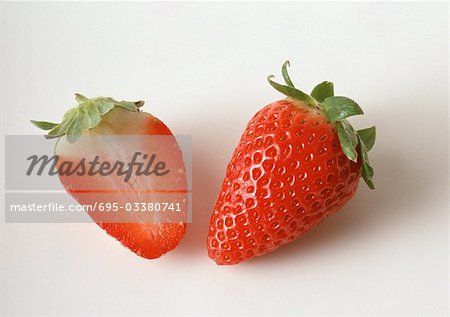 Strawberry and strawberry half, close-up