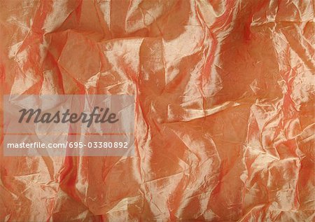 Wrinkled light orange silk, close-up, full frame