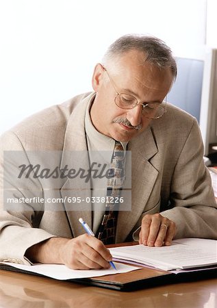 Man sitting at desk, writing