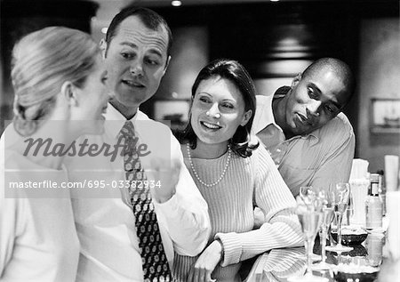 Group of business people socializing at bar, b&w.