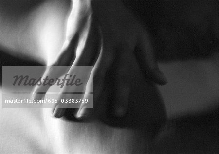 Woman's hand on arm, close-up, blurred black and white.