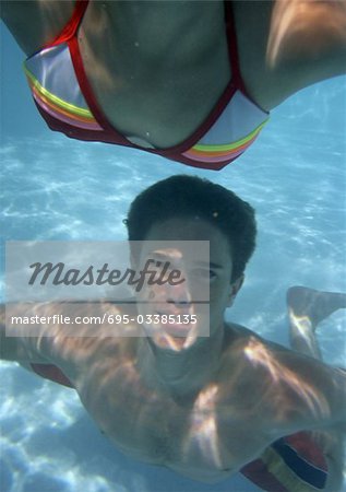 Close-up of teenagers swimming in pool.