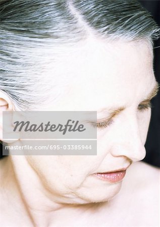 Mature woman looking down, close-up, portrait