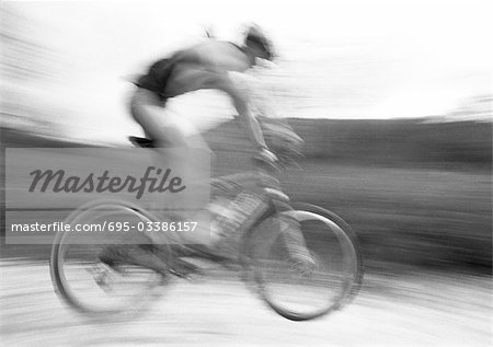 Man cycling, side view, blurred, b&w.