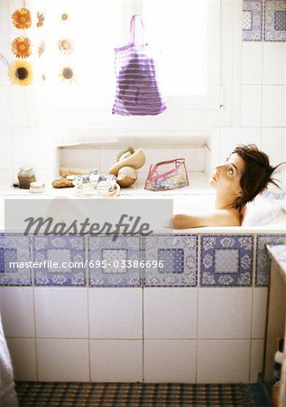 Woman taking bath, man sitting on side of bathtub, looking down at woman -  Stock Photo - Masterfile - Premium Royalty-Free, Code: 695-03381854