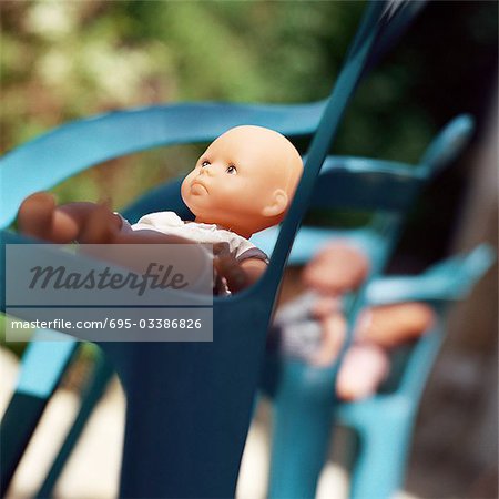 Baby dolls sitting in chairs