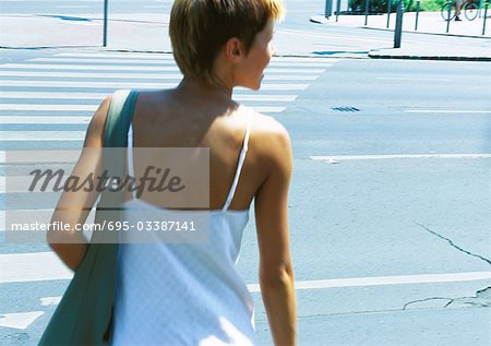 Woman crossing street, rear view