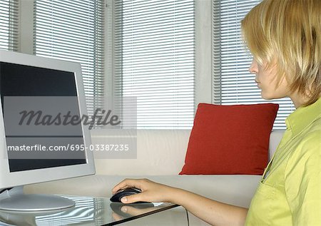 Teenager using computer, side view