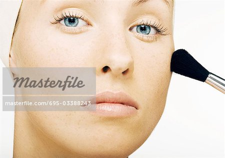 Woman applying blush, close-up