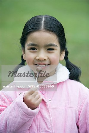 Girl holding lollipop, portrait