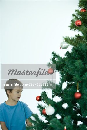 Boy standing near Christmas tree