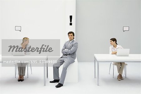Man sitting in office with exclamation mark over his head, women on either side with blank word bubbles