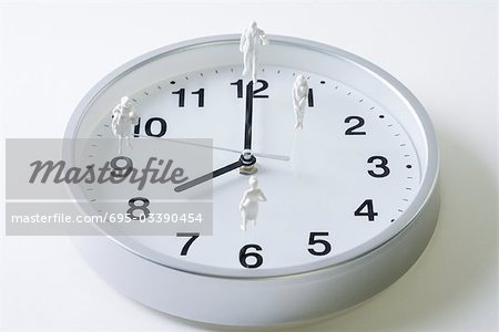 Miniature figures standing on surface of clock