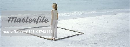 Woman standing inside square on beach