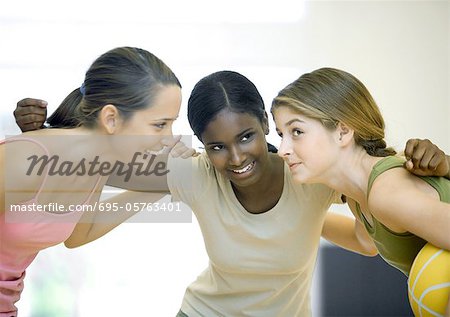 Teen girls huddling with basketball