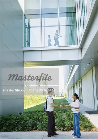 Two students shaking hands on campus