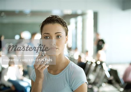 Woman using cell phone in airport
