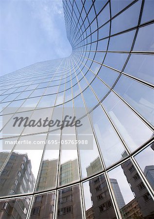 Skyscraper with reflection of buildings on facade, low angle, abstract view