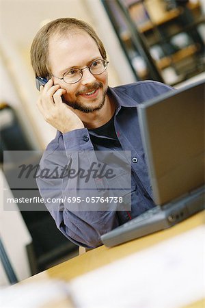 Man using laptop and cell phone