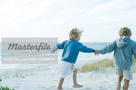 Children holding hands on beach