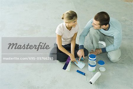 Couple sitting on floor looking at color swatches