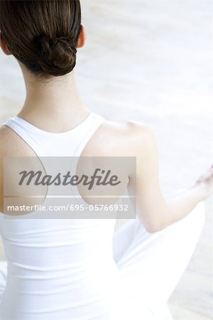 Woman sitting in lotus position, rear view