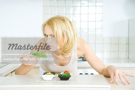 Woman leaning over food, looking at camera threateningly