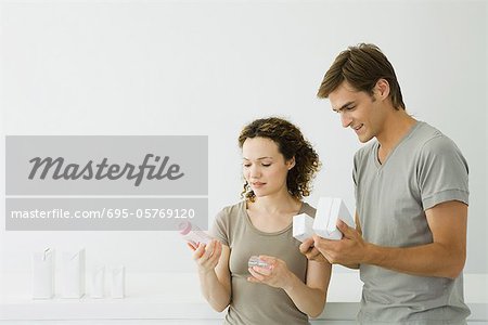 New parents looking at baby bottle, man holding milk cartons