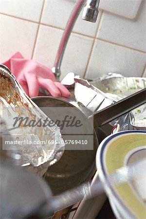 Kitchen sink piled over with dirty dishes