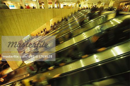 Escalators in crowded shopping mall