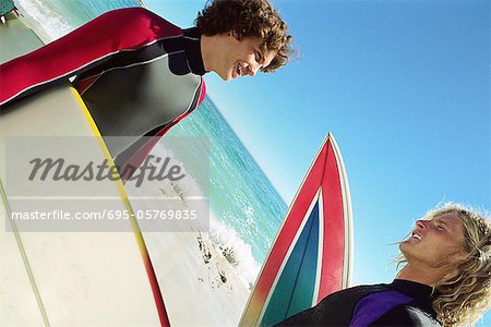Surfers on beach having conversation
