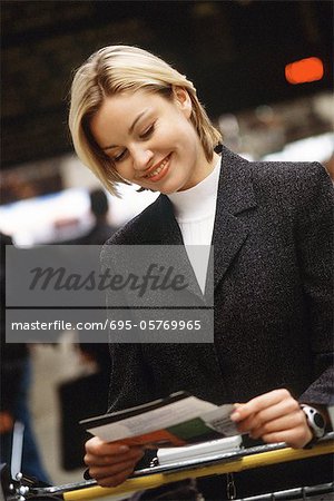 Woman smiling looking at travel ticket