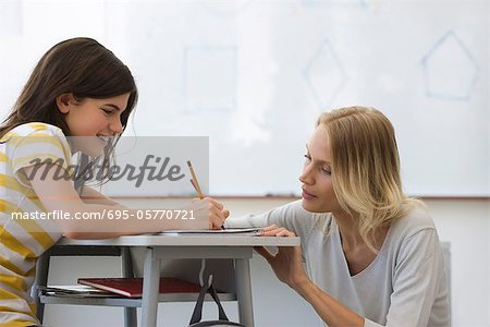 Female teacher helping high school student