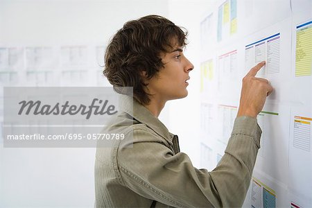 Male college student checking results posted on bulletin board