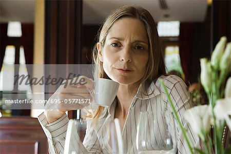 Mature woman having coffee in restaurant
