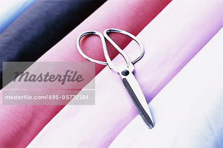 Scissors on rolls of fabric