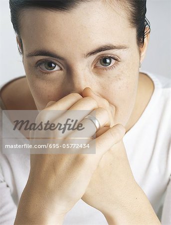 Woman covering mouth and nose with hands, portrait