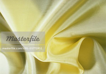 Folds in yellow silk, close-up, full frame