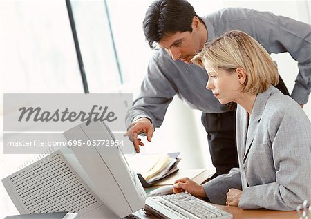 Businessman and businesswoman looking at computer screen