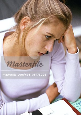 Woman sitting, head against hand, close-up, high angle view