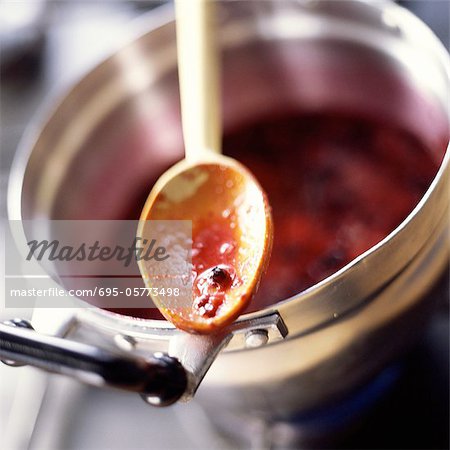 Close-up of spoon with berry juice over pot