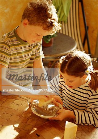 Two children grating cheese